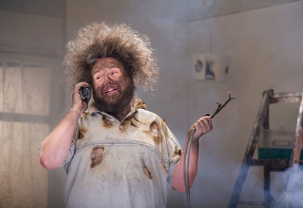 Electrocuted man holding a fried cable.
